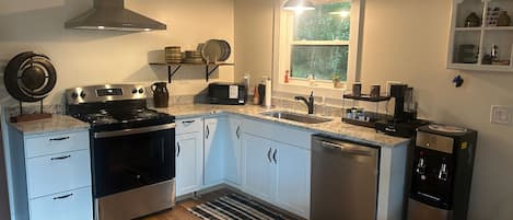 A modern kitchen with a stove, oven, microwave, and dishwasher.