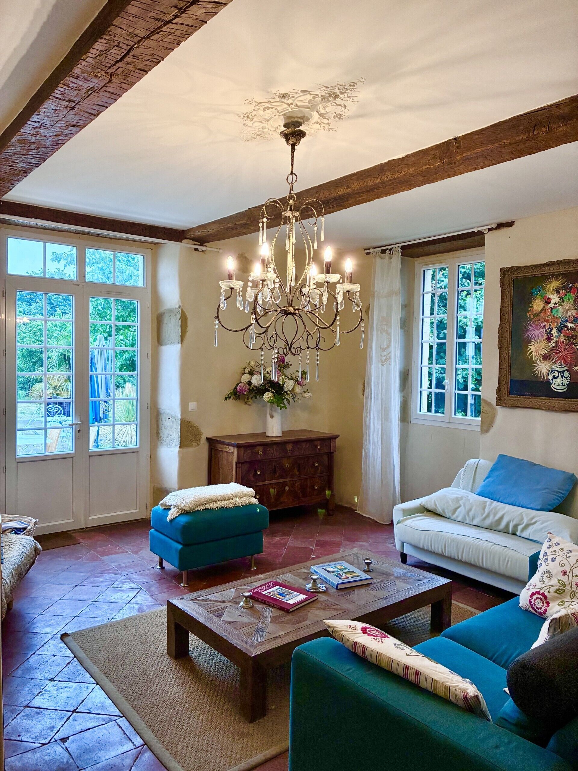A living room with a chandelier, two sofas, a coffee table, and a cabinet.