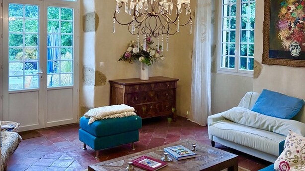 A living room with a chandelier, two sofas, a coffee table, and a cabinet. - Maison Laurent - The Gers, at the end of the road. (Margouët-Meymes)