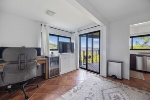 Eine moderne Küche mit Blick ins Freie, ein Essbereich mit Tisch und Stühlen sowie ein Arbeitsbereich mit Schreibtisch und Stuhl.