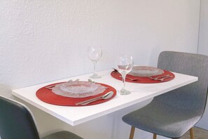 A dining table with two red placemats, silverware, and wine glasses. - Comfort stay 7 Min from Disney & Universal | Orl (Kissimmee)