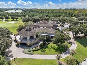 A large residential property with multiple buildings, a well-maintained lawn, and a golf course in the background. - Cozy Unit Near Disney World + Free Parking | Orl (Kissimmee)
