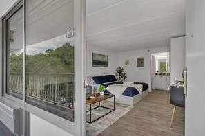 A modern interior with a balcony, a bed, a desk, and a kitchen area. - Magic Stay Near Disney Parks | Orl (Kissimmee)