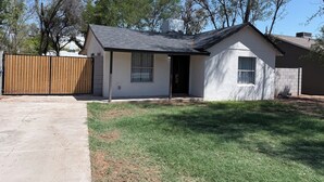 A single-story house with a front door, a small porch, and a fenced backyard. - Modern 3BD Central Phoenix Home (Phoenix)
