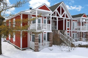 A multi-story house with a red exterior, white trim, and a stone foundation. - Cozy Spacious Resort Suite With Kitchen and Living Room (Oro-Medonte)