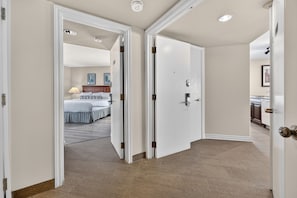 A hotel hallway with a bed, a bathroom, and a kitchen area. - Cozy Spacious Resort Suite With Kitchen and Living Room (Oro-Medonte)