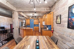 A rustic kitchen with wooden cabinets, a central island, and pendant lighting.