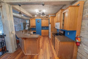 A kitchen with wooden cabinets, a granite countertop, and a built-in oven.