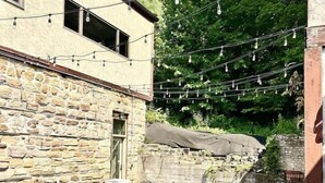 A rooftop patio with outdoor furniture and string lights.