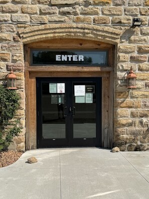 A stone building with a wooden archway and a sign that reads 'ENTER'. - Charming 1863 Brewery Loft + Underground Caves (Jordan)