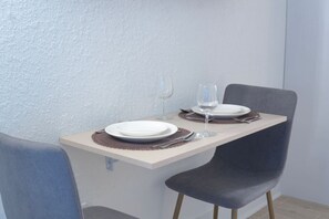 Una mesa de comedor con dos platos, una copa de vino y cubiertos.