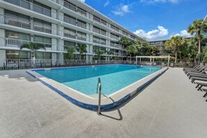 Un hôtel doté d’une piscine, de nombreux balcons et de palmiers.
