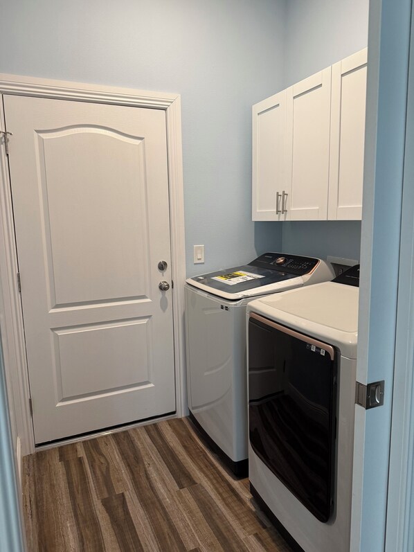 A compact laundry room with a white door, a washing machine, and a dryer.