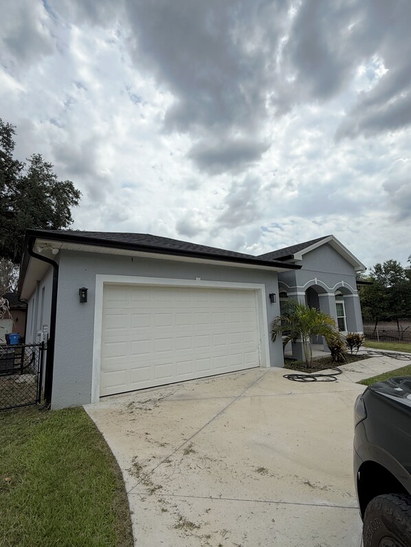 A residential house with a garage, a driveway, and a lawn. - Furnished 3 bedroom, easy I-4 Access (Plant City)