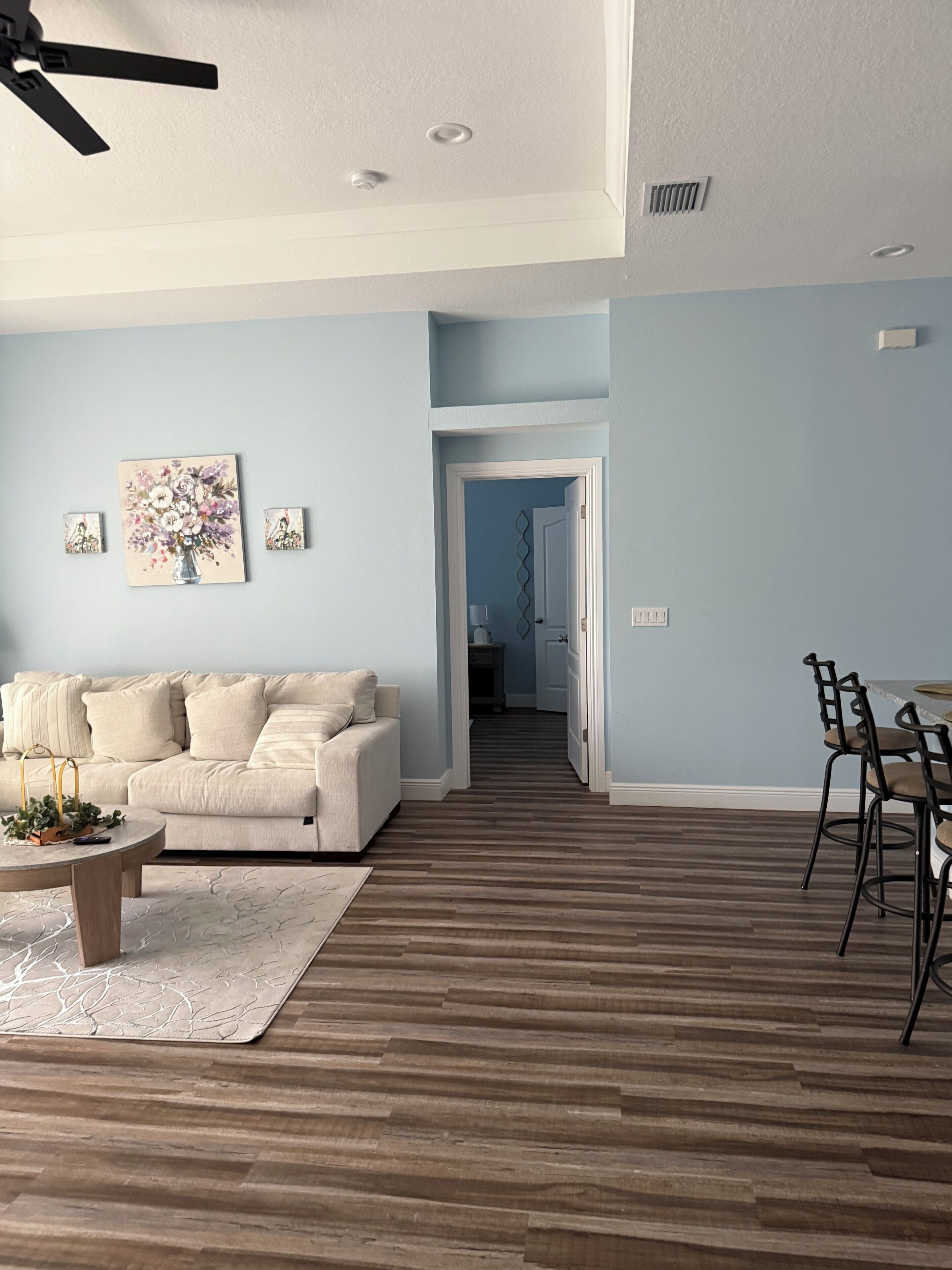 A living room with a sofa, coffee table, and artwork on the wall.