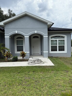 A two-story house with a front porch, a garage, and a well-maintained lawn. - Furnished 3 bedroom, easy I-4 Access (Plant City)