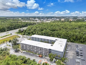 Eine mehrstöckige Tiefgarage mit flachem Dach, umgeben von Grünflächen und blauem Himmel.