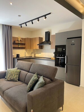 A modern kitchen with a built-in oven, microwave, and refrigerator.