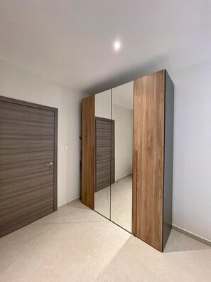 A room with a large wardrobe and a mirror.