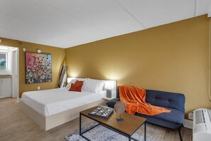 Ein Hotelzimmer mit Bett, Sofa, Tisch und einem Bild an der Wand.