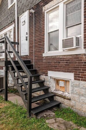 Un bâtiment en briques avec un escalier menant à une porte portant le numéro 2.