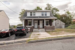A two-story house with a front porch, a garage, and a fenced yard.