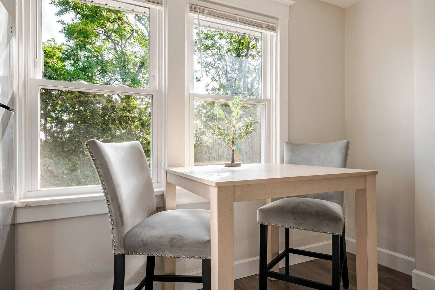 A corner room with a window, a table, and two chairs.