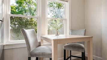 A corner room with a window, a table, and two chairs.