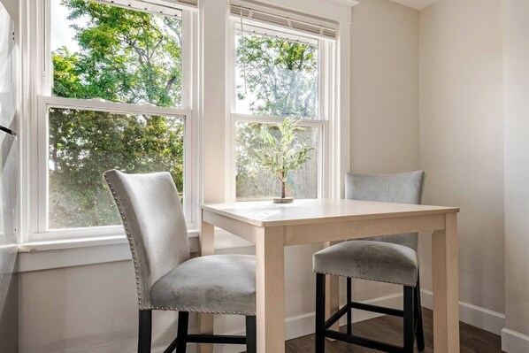A corner room with a window, a table, and two chairs.
