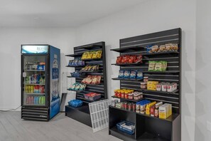 Ein Getränkeautomat und Regale mit Snacks und Soßen.