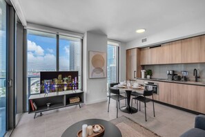 A modern apartment with a dining area, kitchen, and a large window with a city view. - Stunning Skyline & Bay View Luxury Apartment (Miami)