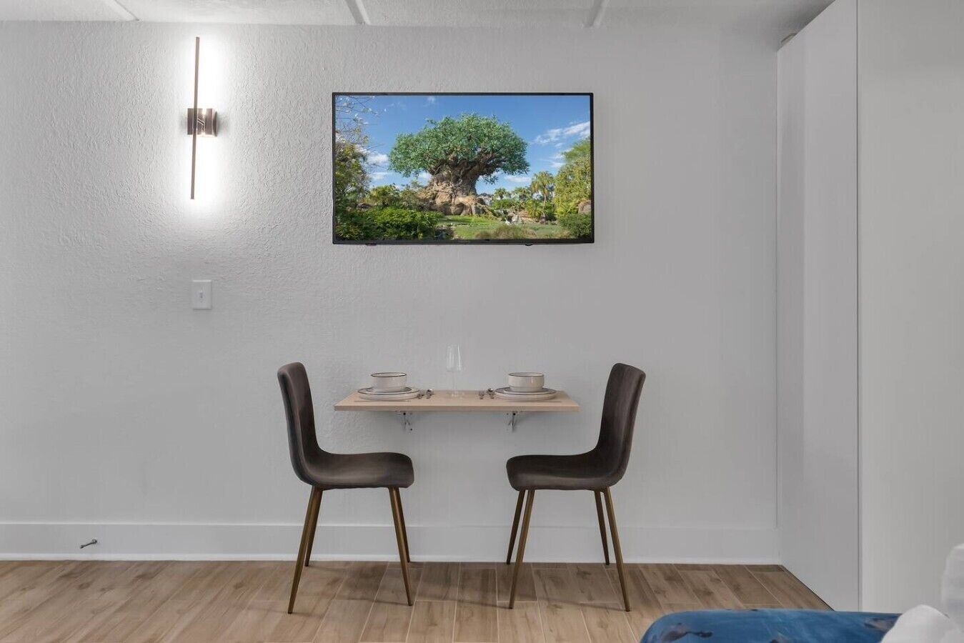 Un comedor con una mesa, dos sillas y un cuadro en la pared.