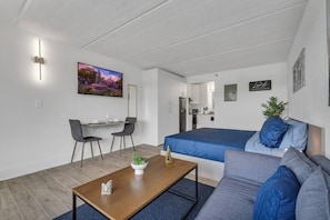 A modern, compact living space with a bed, sofa, dining area, and kitchenette. - Best Disney Location + Pool & Free Parking | Orl (Kissimmee)