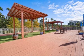 A wooden deck with a pergola, outdoor seating, and potted plants. - Cozy Retreat with Stunning Water View | Fort Myers (Fort Myers)