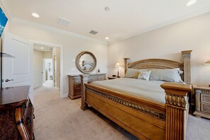 A bedroom with a large bed, a dresser, a mirror, and a nightstand. - Gulf Breeze Getaway 4BR St Pete Family Retreat (St. Petersburg)
