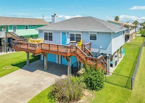 Ein zweistöckiges Haus mit einer Holzterrasse und einer Satellitenschüssel.