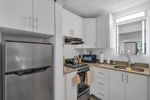 Una cucina moderna con elettrodomestici in acciaio inossidabile, un forno a microonde e un lavello.