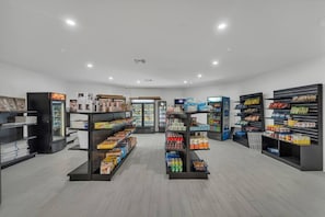 A clean, well-lit grocery store with shelves stocked with various products and a refrigerated display case. - Modern Condo Near Disney + Parking | Orl (Kissimmee)