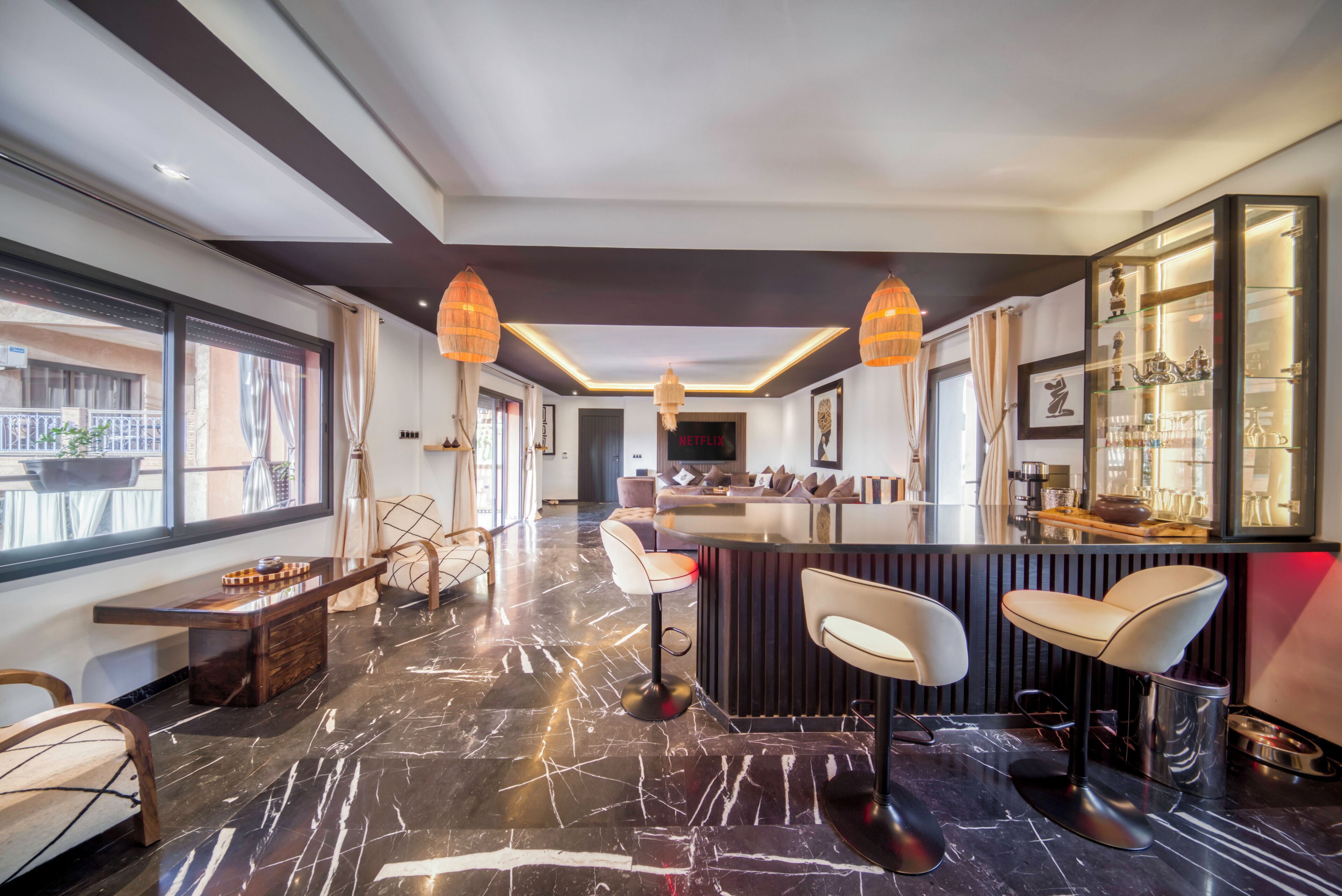 Een moderne hotelentree met een marmeren vloer, een bar en zithoekjes.
