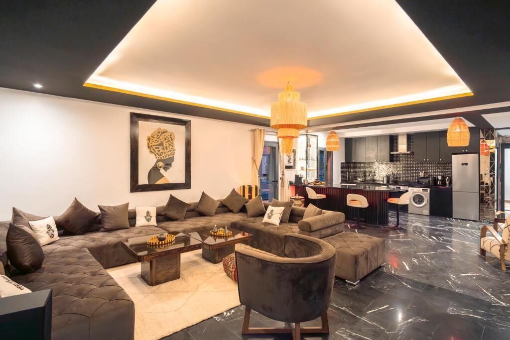 A modern living room with a sectional sofa, a coffee table, and a fireplace.
