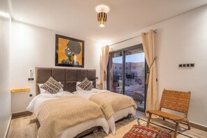 Un dormitorio con una cama grande, una silla, un cuadro y vistas al exterior.