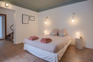A bedroom with a bed, two bedside lamps, a nightstand, and a staircase. - L'Élégante - Petfriendly - Proche gare (Laval)