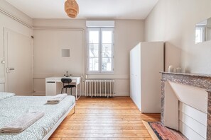 A bedroom with a bed, a desk, a radiator, and a window. - L'Espine - Hyper centre - Tramway (Angers)