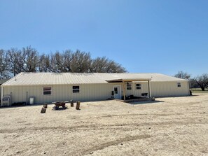 A single-story building with a flat roof, a covered porch, and a small front yard. - 3-bedroom house in peaceful Pottsville (Pottsville)