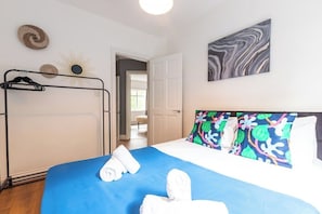 Et hotelværelse med en seng, et klædeskab og en dør til et andet rum.