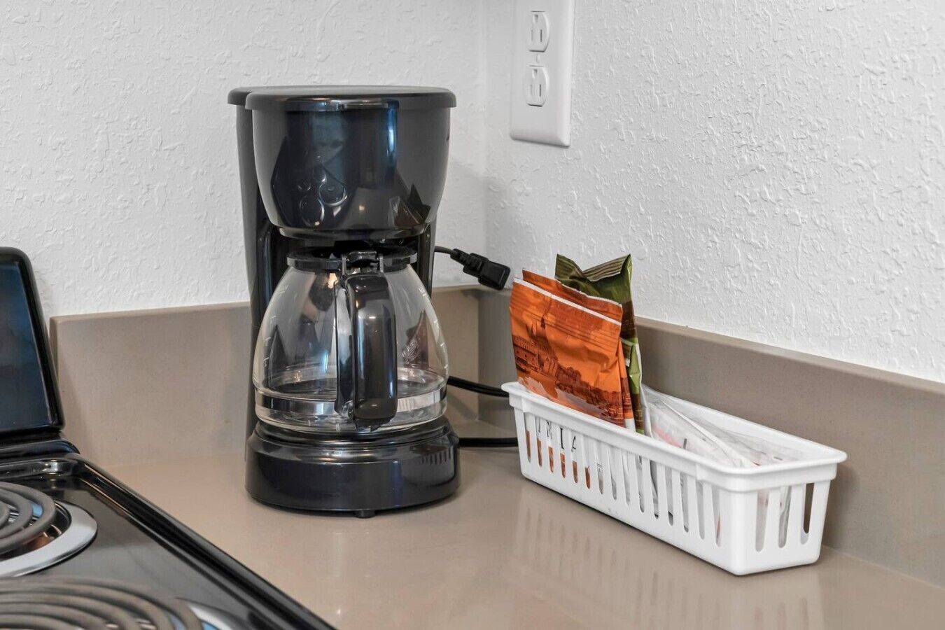 En kaffemaskine på en køkkenbordplade med en holder til kaffekapsler.