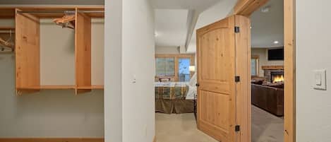 Ein Flur, der zu einem Schlafzimmer mit Kleiderschrank und einem Wohnbereich mit Kamin führt.