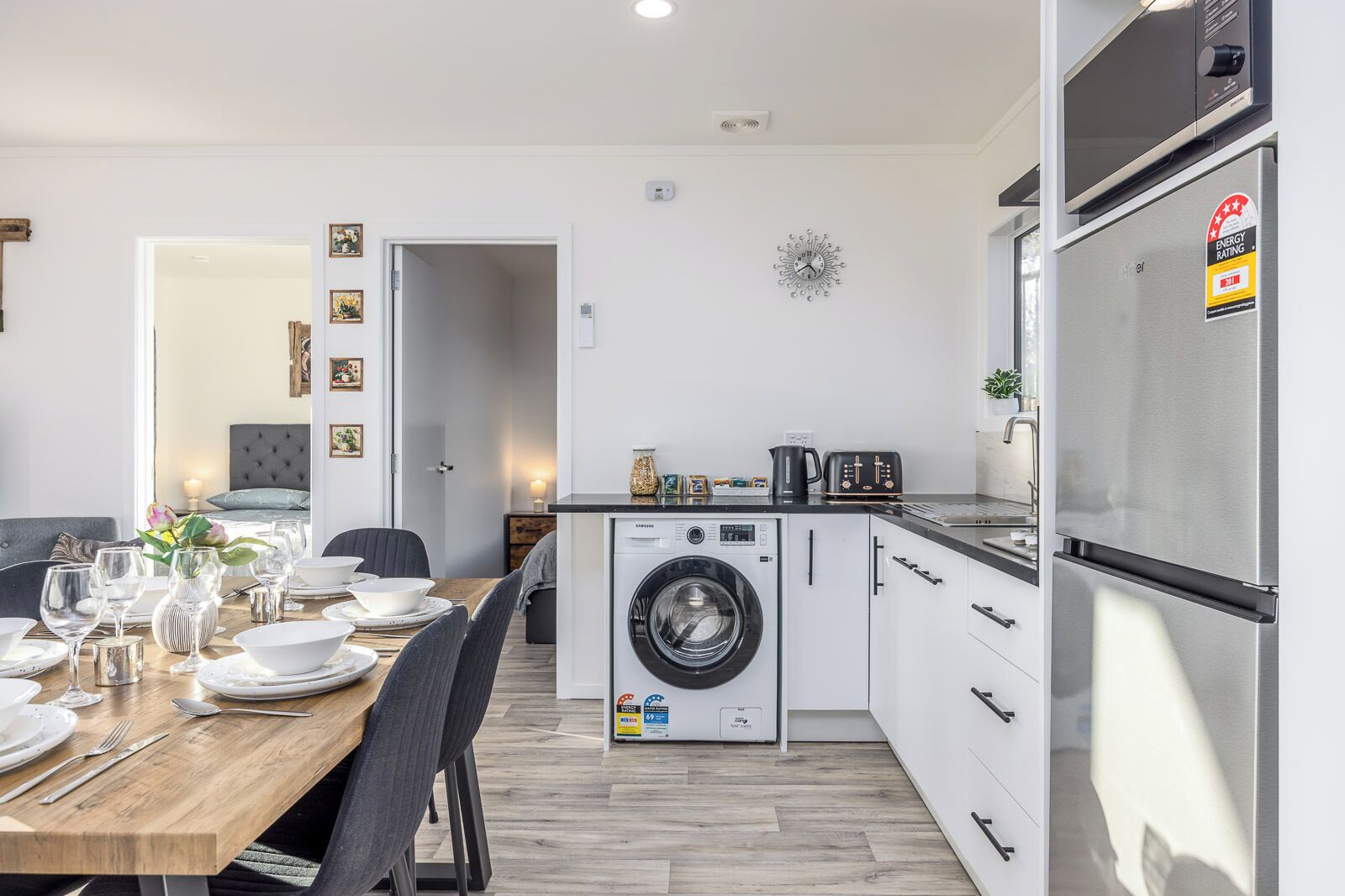 Eine kompakte Küche mit Waschmaschine, Kühlschrank und Essbereich mit Tisch für vier Personen.