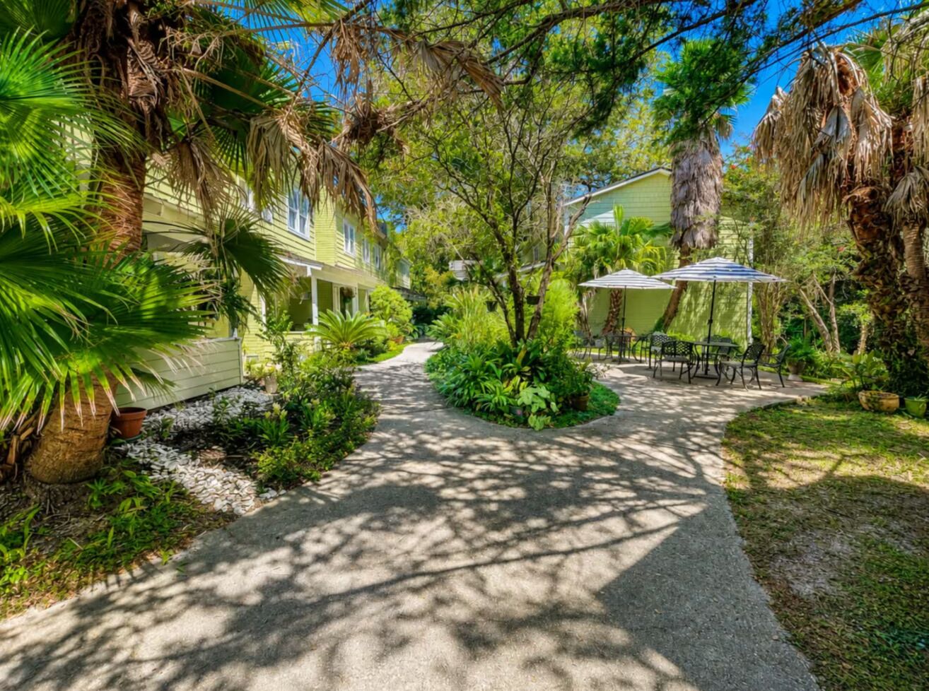 A pathway leading to a house with a patio area.