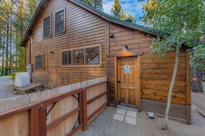 A wooden cabin with a porch, a mailbox, and a door with a sign. - Bearfoot Cabin - Central Tahoe Cabin (South Lake Tahoe)